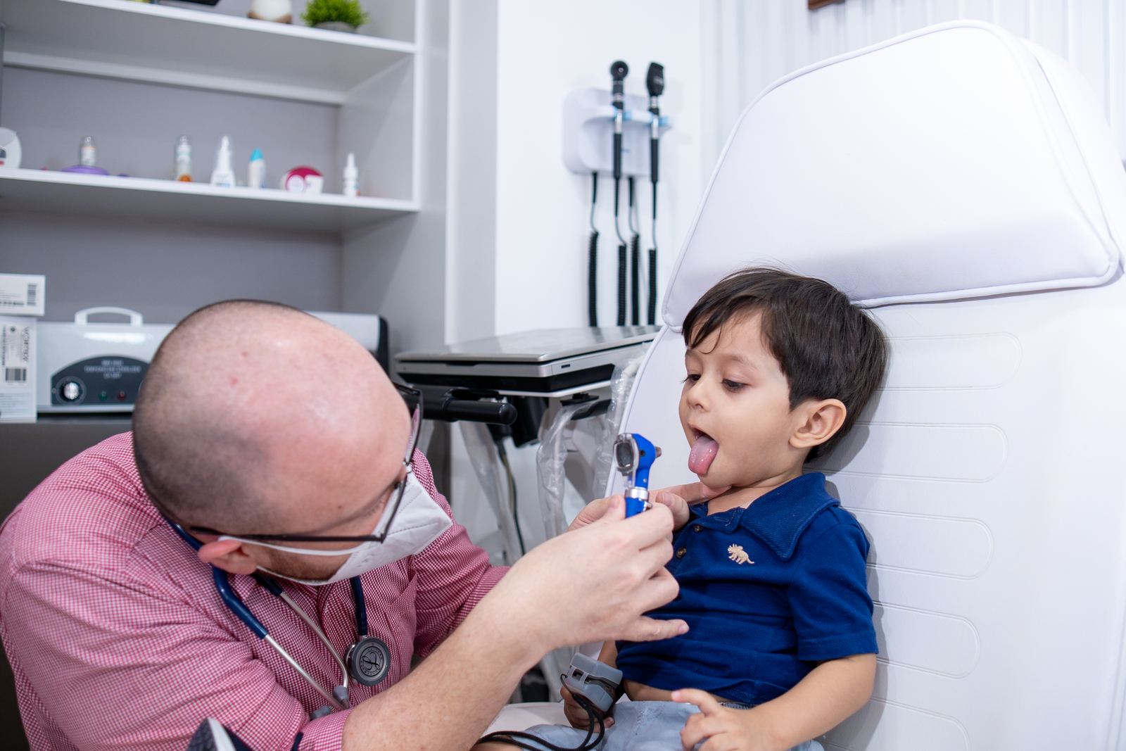 Dr. Jigal Meza revisando la garganta de un niño en consulta