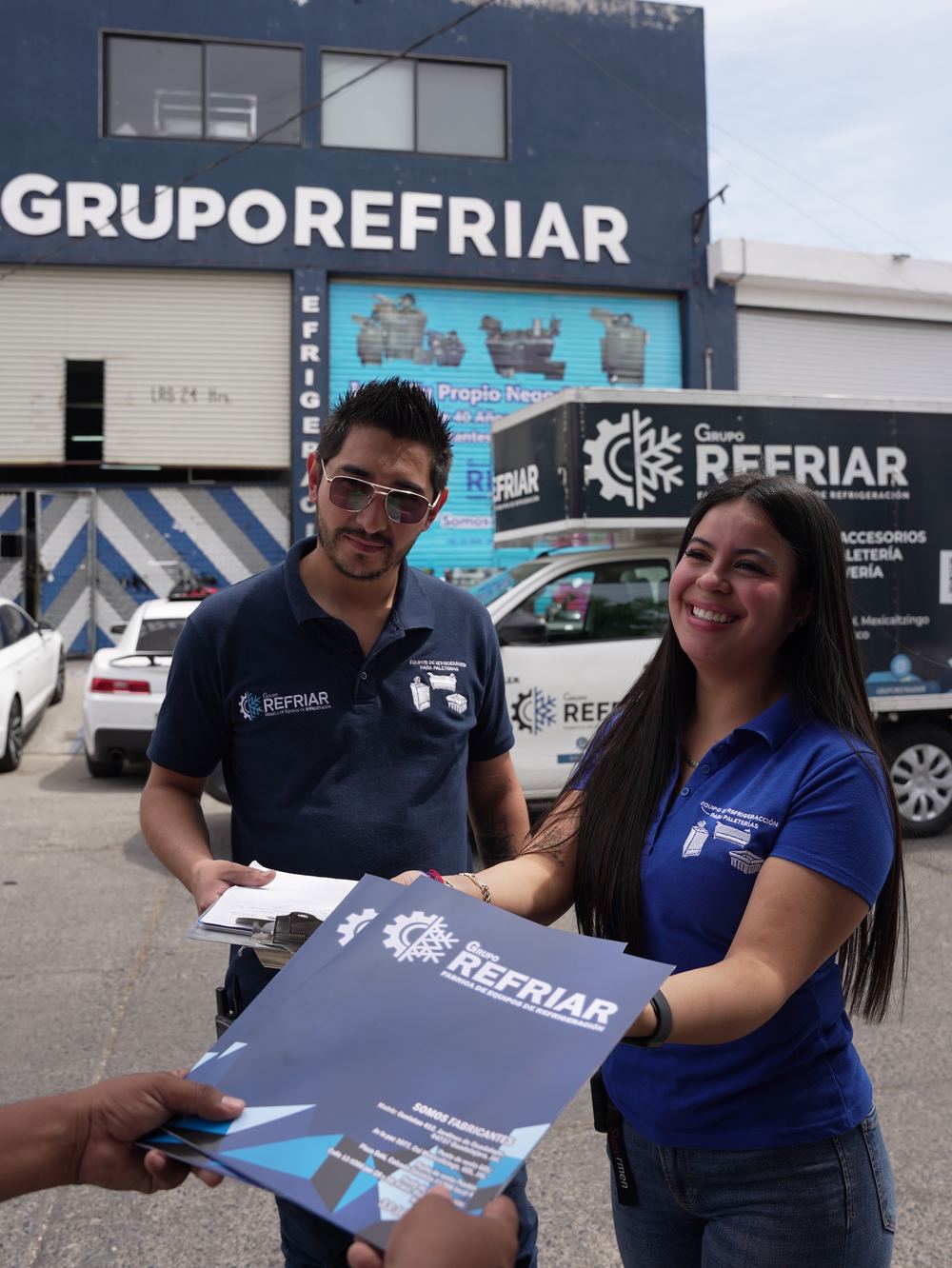 Equipo de ventas de Grupo Refriar con su catálogo