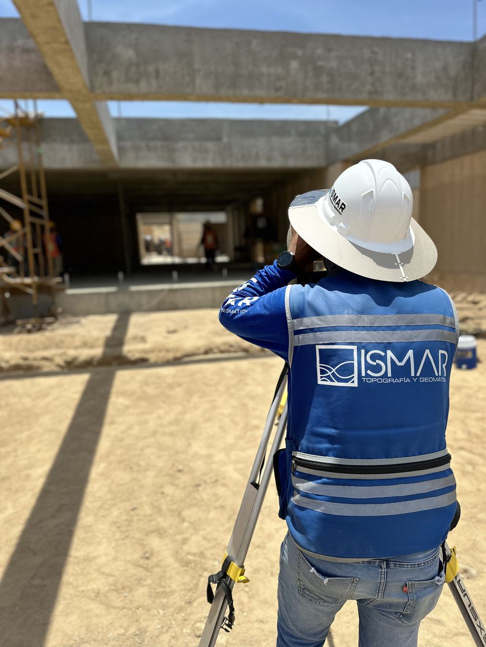 Topógrafo de ISMAR midiendo con estación total en construcción