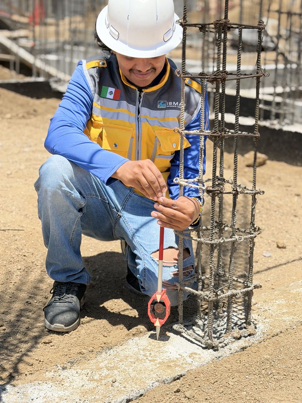 Topógrafo revisando armado de columna en obra